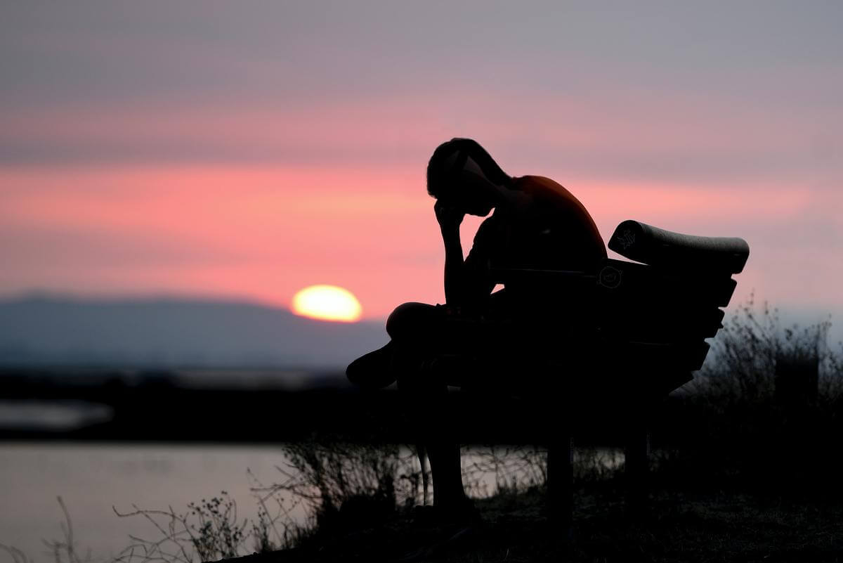 homme-depressif-fatigue-assis-banc-coucher-soleil